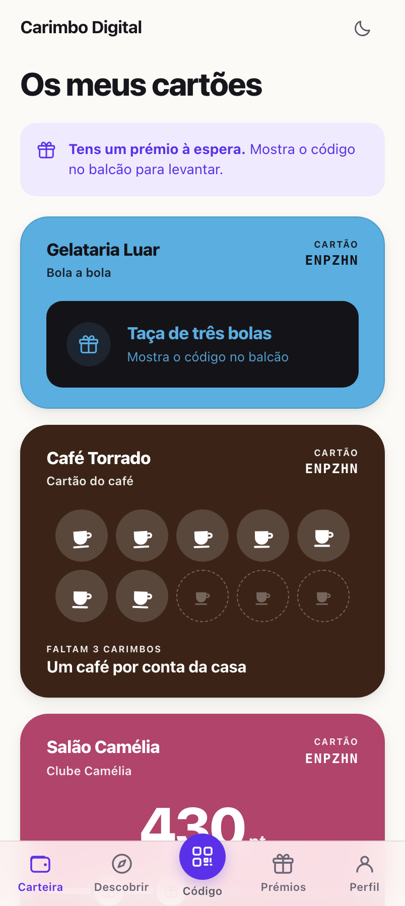 O ecrã «Os meus cartões»: um aviso roxo a dizer «Tens um prémio
                à espera», o cartão azul da Gelataria Luar com uma taça de três
                bolas por levantar, o cartão castanho do Café Torrado com sete
                chávenas carimbadas de dez, e a barra de baixo com Carteira,
                Descobrir, Código, Prémios e Perfil.